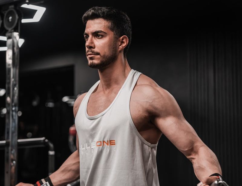 Athletic man focused on his training routine in a dark studio.