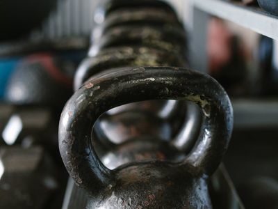 Close up of a kettlebell on a dark rubber gym floor.